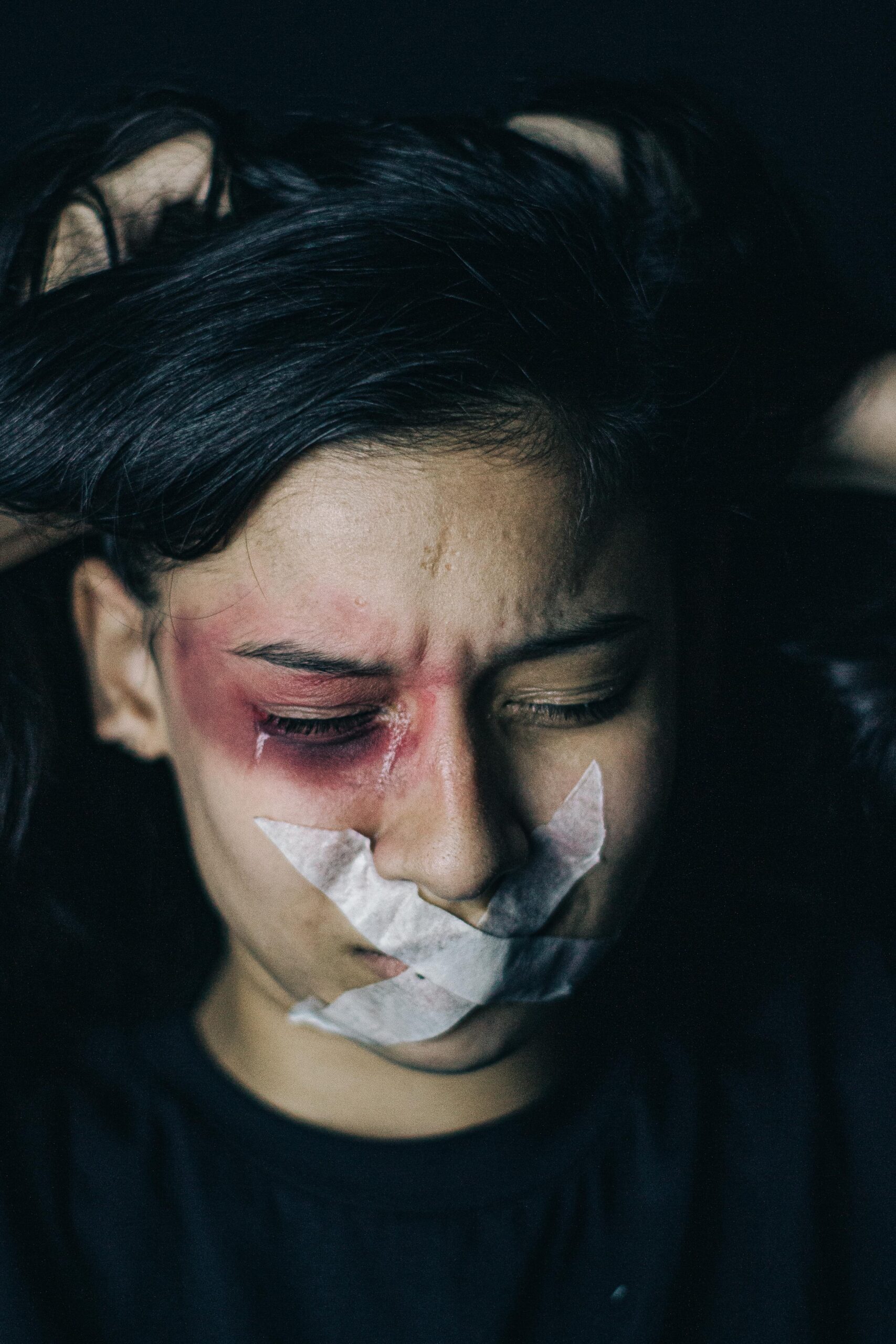 a child crying with tape on her mouth